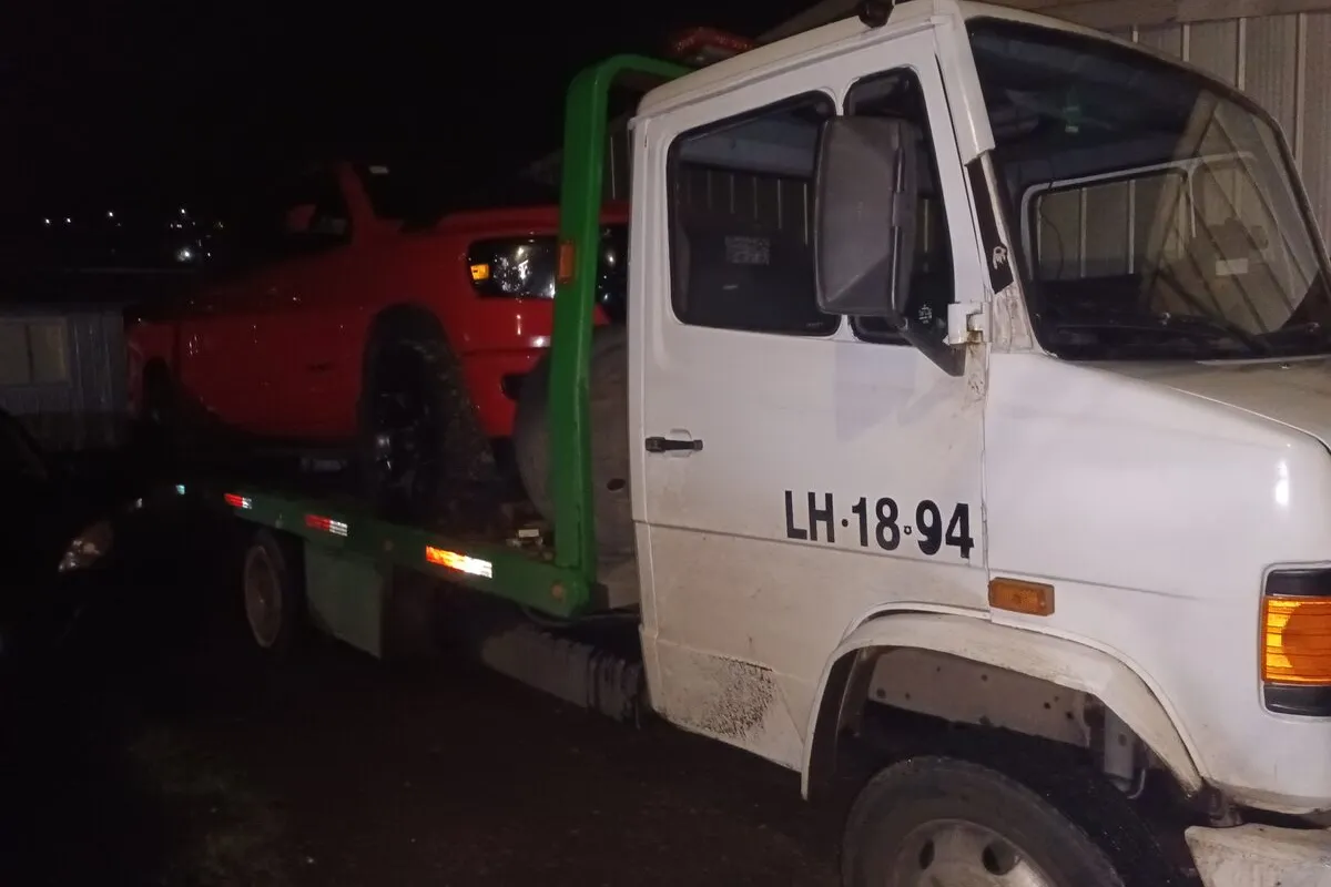 Grúa AutoGrúas Concepción trasladando un vehículo de noche